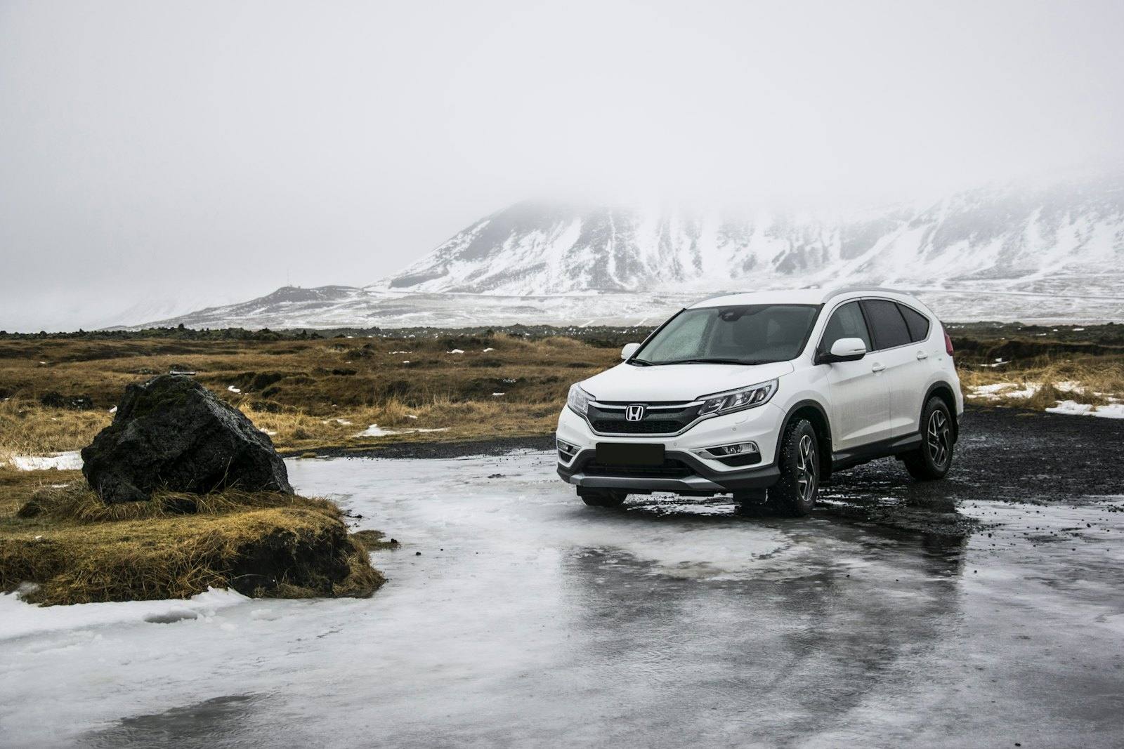 White compact SUV parked on a wet road
